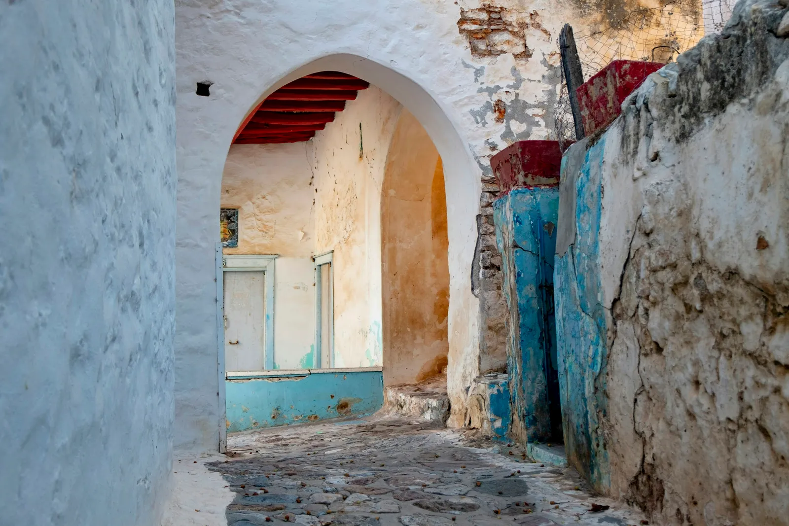 A narrow Stone Town alley through an arched passage