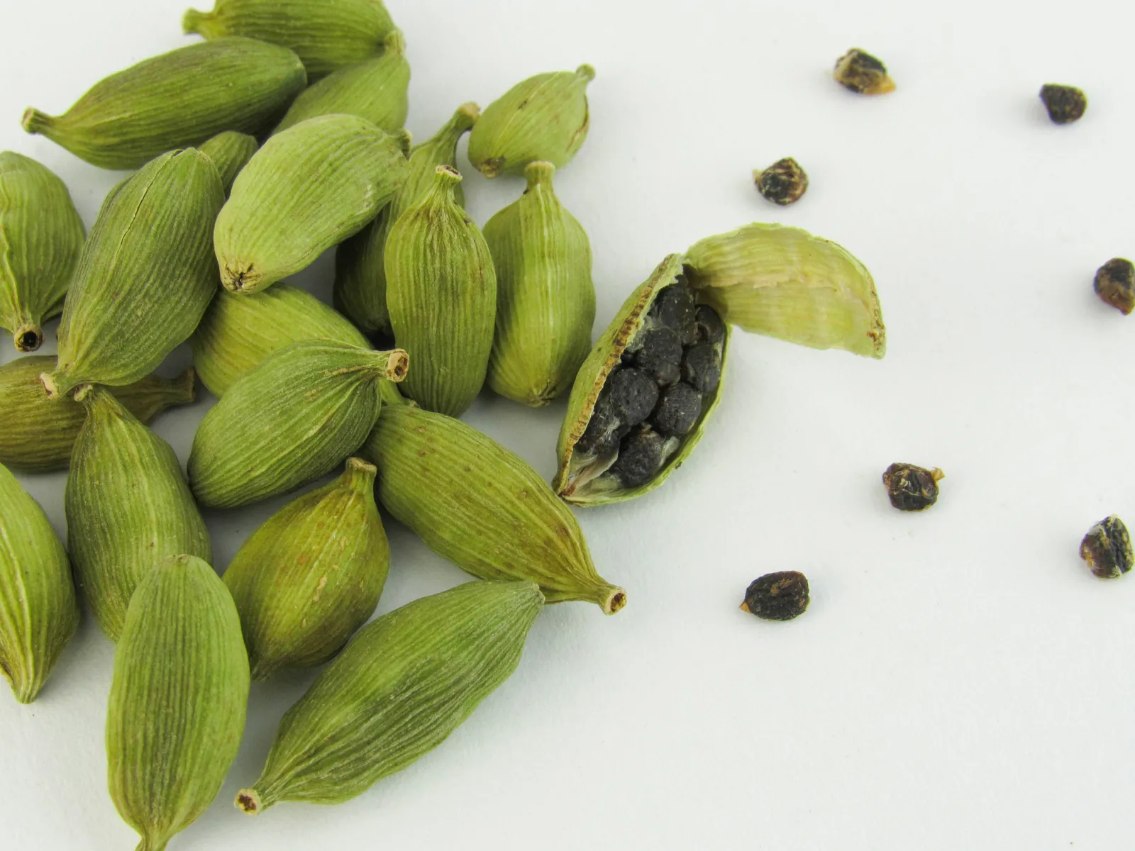 Green cardamom pods piled on a table