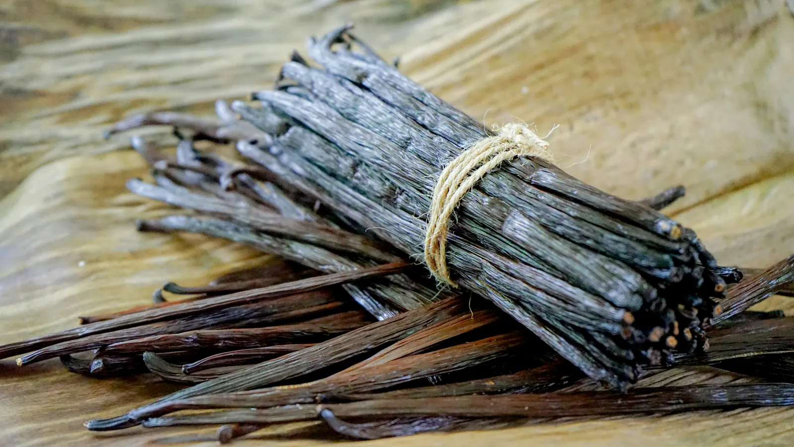 Cured vanilla pods laid on a wooden table